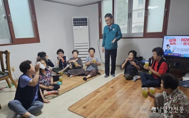 주영홍 밀양시 내이동장이 남부경로당을 방문해 사탕수수 음료를 전달하며 안전 점검과 함께 어르신들에게 안부를 전하고 있다.