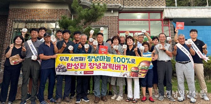 창녕군농업인단체협의회와 농업기술센터 직원들이 창녕 갈릭 버거를 손에 쥐고 단체사진을 촬영 중이다.