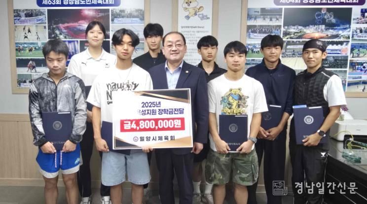 장학금을 받은 학생들이 민경갑 밀양시체육회장과 함께 기념 촬영을 하고 있다.