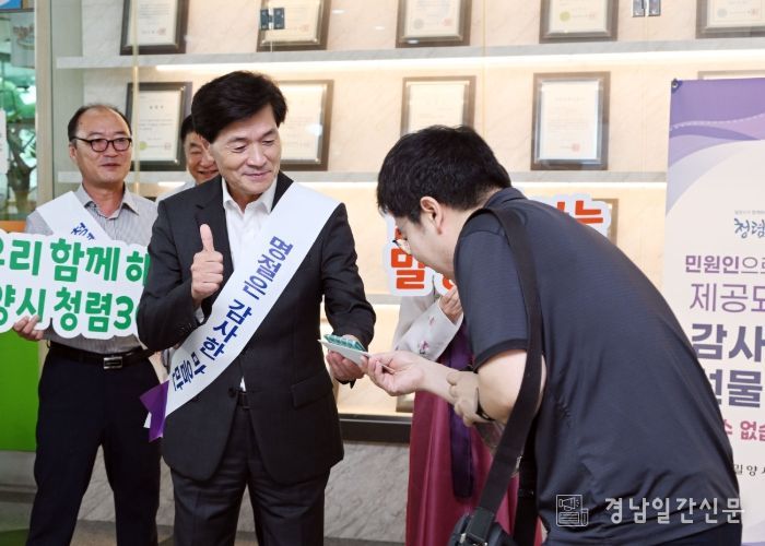 안병구 밀양시장이 출근길 청렴 캠페인에서 직원에게 청렴 홍보 물품을 전달하고 있다.