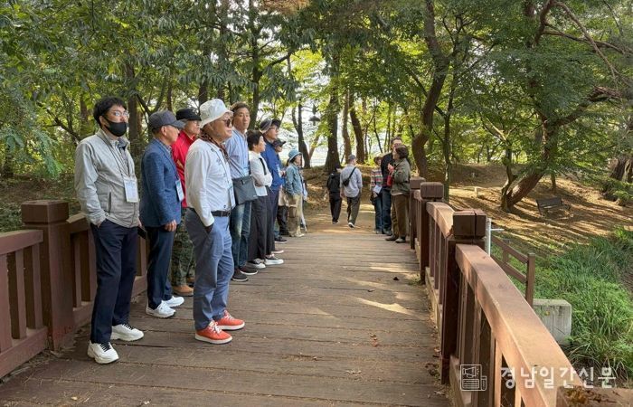 - 25일 열린 밀양 전입자 웰컴투어에서 참가자들이 위양지 둘레길을 걸으며 문화관광해설사 설명을 듣고 있다.